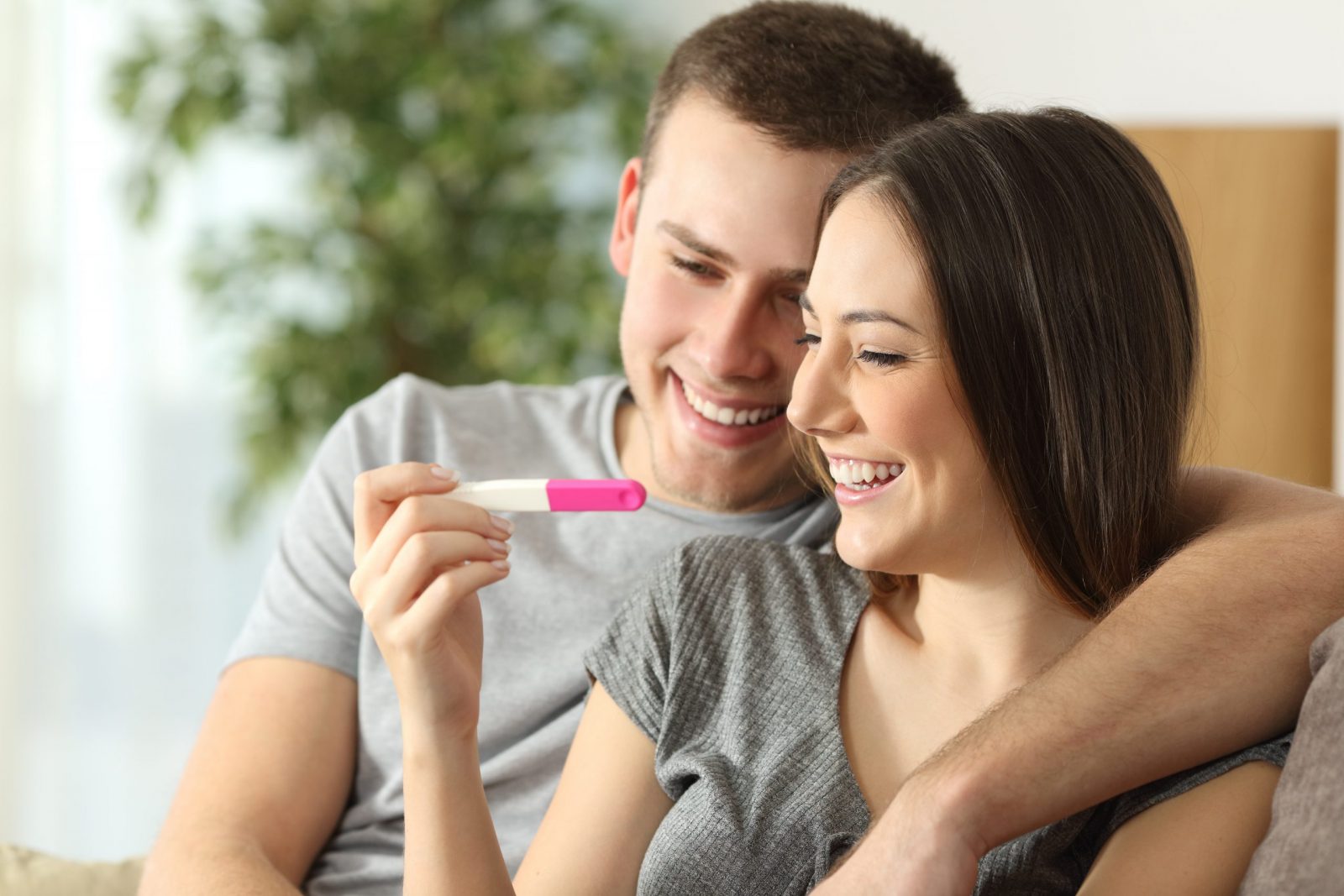 male and female couple looking at pregnancy test